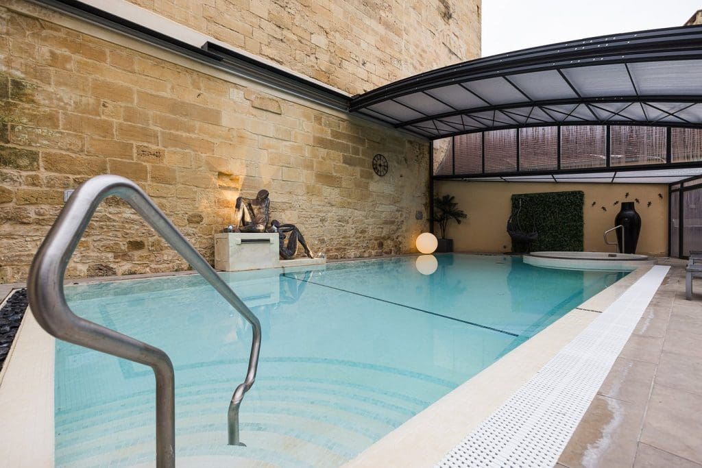 Outdoor pool at Plaza Madeleine & Spa in Sarlat, surrounded by lounge chairs