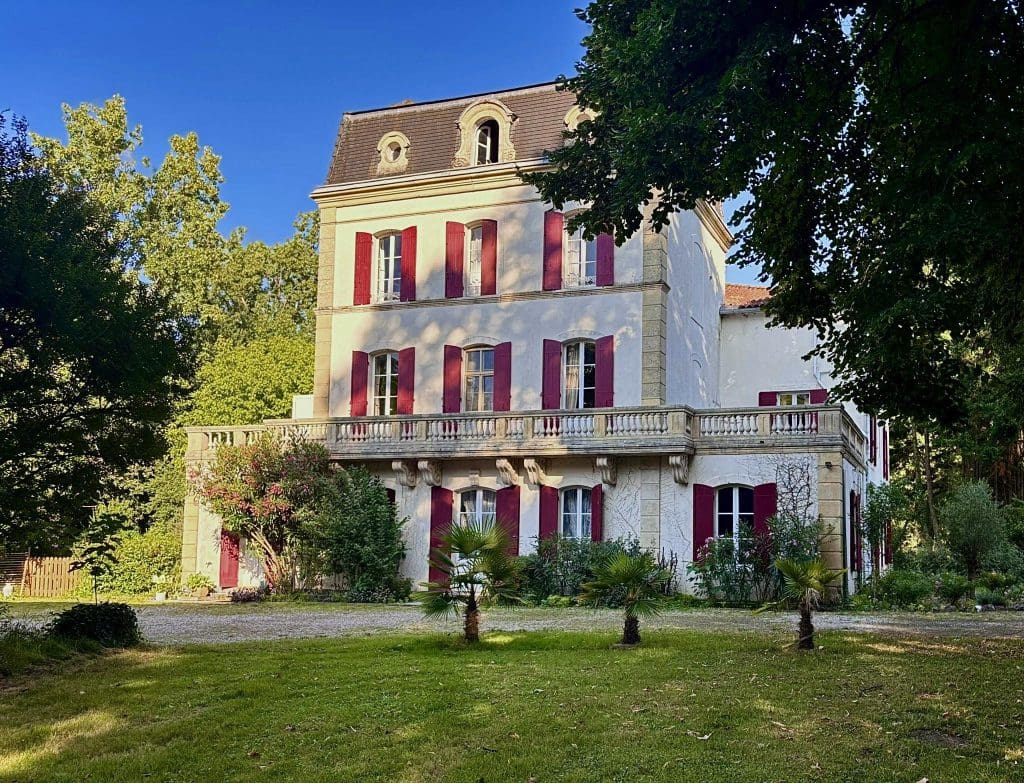 Façade of Domaine La Gazaille de Camille with red shutters
